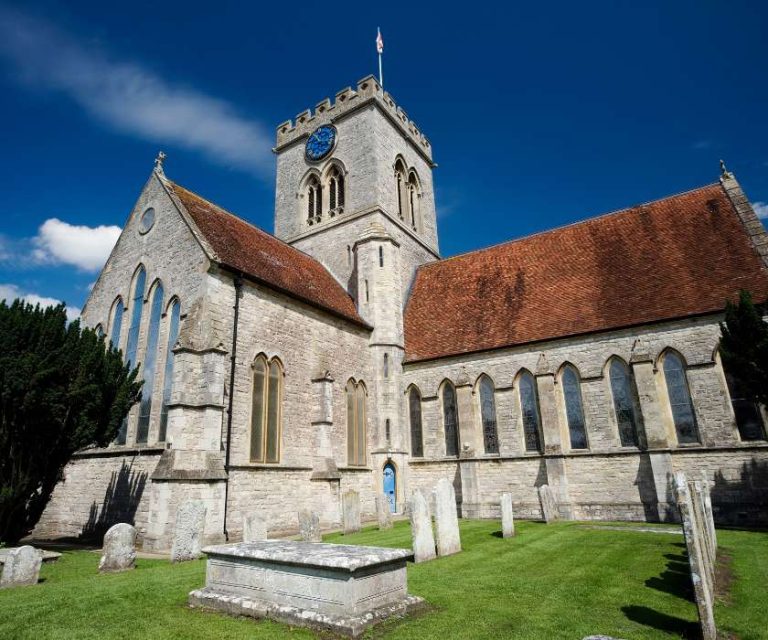 Stately church with a clock tower and historic gravestones in Ringwood.