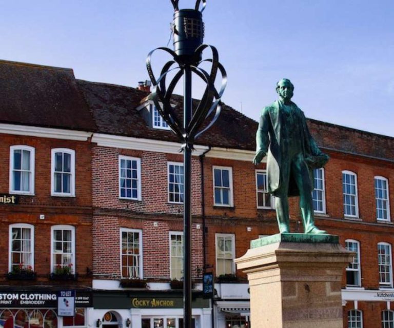 Statue of Lord Palmerston in Romsey town centre, with traditional red-brick buildings in the background.