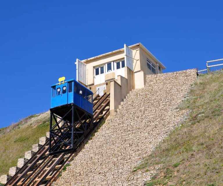 Blue cliff railway carriage ascending the steep incline at Southbourne on a sunny day.